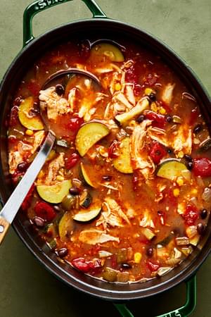 a pot of chipotle chicken soup made with onion, bell pepper, garlic, black beans, zucchini, chipotle chilis and spices