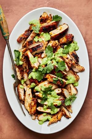 homemade citrus chicken sliced on a platter with a serving fork dried with ginger jalapeño sauce