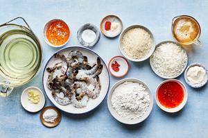 ingredients for homemade coconut shrimp with curry sauce and ginger mayo in bowls on the counter
