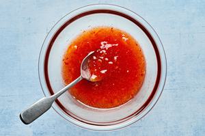 homemade curry sauce made with sweet chili sauce, orange marmalade and red curry paste in a bowl with a spoon