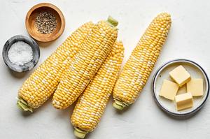 4 ears of corn, butter slices, salt and pepper in bowls to make homemade corn not he cob