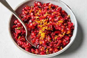 homemade cranberry relish in a bowl with a spoon made with cranberry, apple, orange, sugar, salt and lemon juice