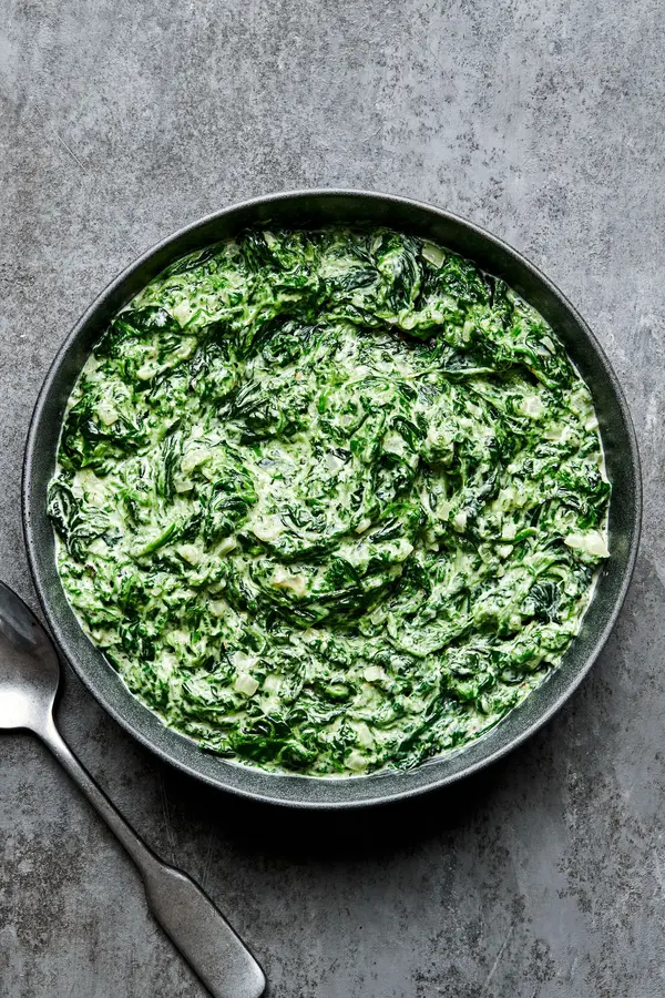 creamed spinach in a serving bowl made with butter, shallot, garlic, cream, dijon, spices and parmesan cheese