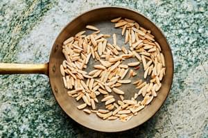 slivered almonds being toasted in a skillet