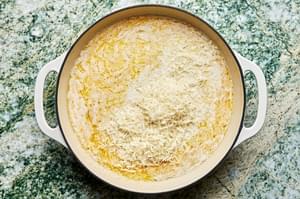 garlic, garlic powder, nutmeg, salt, pepper, butter, cream and parmesan cooking in a skillet