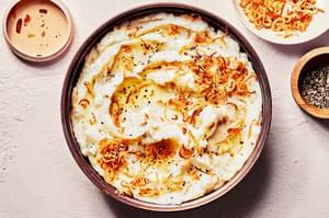 a bowl of homemade crispy shallot mashed potatoes made with butter, milk, garlic powder and salt