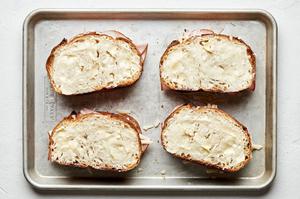4 slices of buttered bread topped with ham, Gruyère cheese and another slice of buttered bread ready to be baked