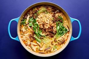 A pot of easy curry ramen with noodles, and vegetables submerged in a golden curry broth