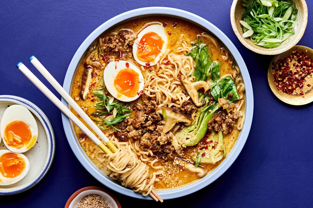 A pot of easy curry ramen with noodles, and vegetables submerged in a golden curry broth topped with soft boiled eggs