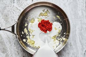 Coconut milk, garlic, fresh ginger and red curry paste in a large skillet to make curry sauce