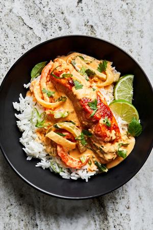 homemade curry Salmon in a bowl over white rice topped with lime.