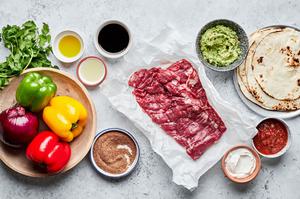 olive oil, lime juice, soy sauce, peppers, skirt steak, onion, tortillas, guacamole, salsa & sour cream in prep bowls
