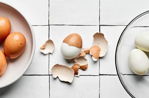 hard boiled eggs being peeled to use to make egg salad sandwiches