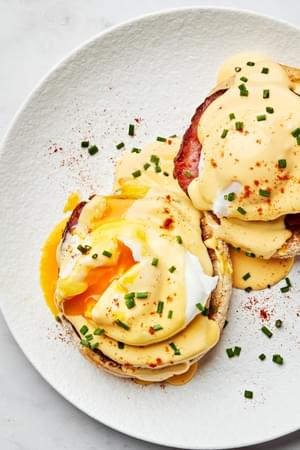 homemade eggs Benedict made with Canadian bacon and homemade hollandaise sauce on a plate