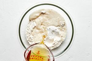 beer, flour, baking soda and salt being added together in a bowl to use for batter for fried fish