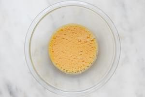 three eggs and salt throughly whisked together in a glass bowl for making a homemade French omelette