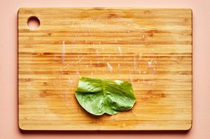 rice paper with a piece of lettuce on top on a cutting board to make fresh spring rolls