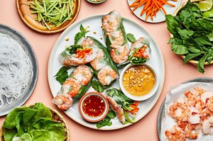 a plate of homemade fresh shrimp spring rolls served with creamy peanut sauce and sweet chili sauce for dipping