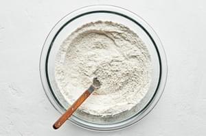 flour, garlic powder, cayenne pepper, salt and pepper being stirred in a bowl to use as breading for fried chicken