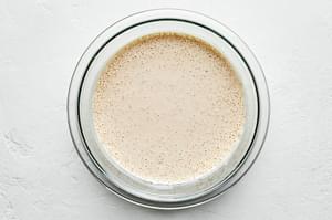 egg batter for fried chicken in a bowl made with egg, buttermilk, flour, garlic powder, cayenne pepper, salt and pepper