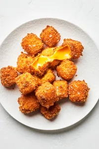 homemade fried cheese breaded with flour, salt, pepper, garlic and panko piled on a plate
