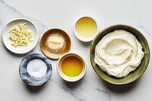 mayo, minced garlic, lemon juice, olive oil, garlic powder & salt in bowls on the counter to make garlic aioli