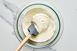 mayo, minced garlic, lemon juice, olive oil, garlic powder & salt being stirred in a bowl to make garlic aioli