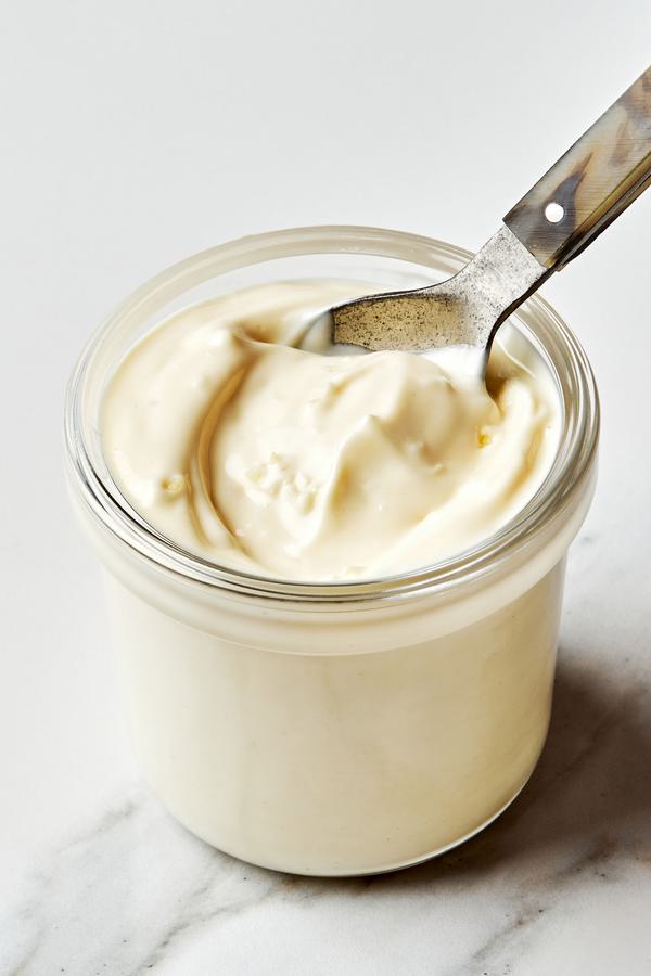 homemade garlic aioli in a jar with a spoon made with mayo, minced garlic, lemon juice, olive oil, garlic powder & salt