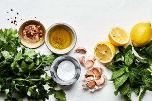 parsley, mint, garlic, olive oil, salt, lemon zest, lemon juice and crushed red pepper in bowls to make homemade gremolata