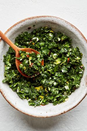 homemade gremolata in a serving bowl with a wooden spoon