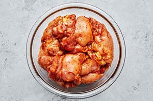 raw boneless chicken thighs marinating in brown sugar, salt, garlic powder, onion powder, paprika, pepper & olive oil