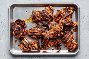 grilled chicken thighs resting on a baking sheet