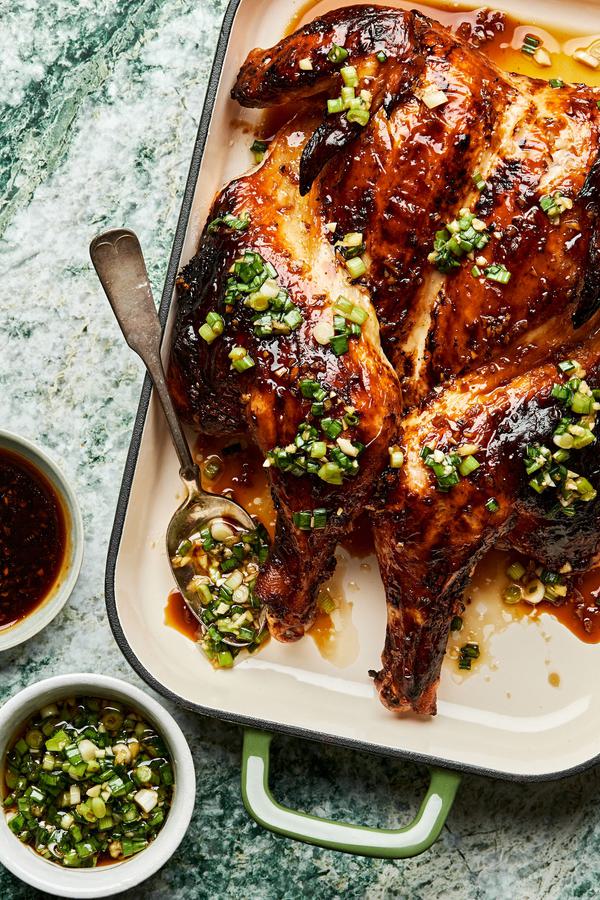 Grilled Lemongrass Chicken drizzled with sriracha-brown sugar sauce and scallion oil next to bowls of extra sauce & oil