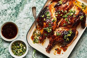 Grilled Lemongrass Chicken drizzled with sriracha-brown sugar sauce and scallion oil next to bowls of extra sauce & oil