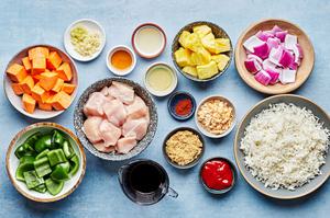 chicken breast, sweet potatoes, pineapple, bell pepper, red onion and other ingredients in bowls for Hawaiian chicken kabobs
