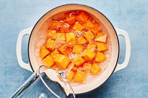 cubed sweet potateos being covered in water in a pot to be balanched before adding to Hawaiian chicken kabobs