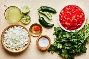 chopped tomatoes, jalapeños, onion, cilantro, salt and lime juice in bowls on the counter to make homemade pico de Gallo