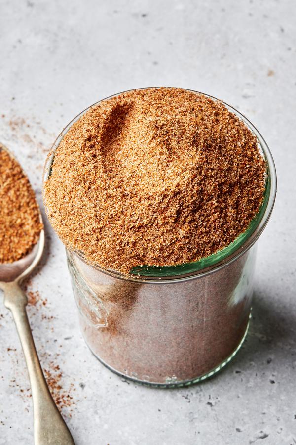 homemade old bay seasoning in a jar next to a spoon full of seasoning