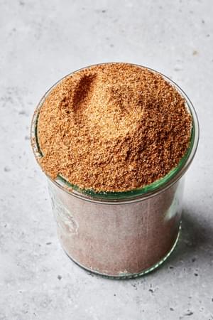 homemade old bay seasoning in a jar made with celery salt, paprika, cayenne, dry mustard, nutmeg, cinnamon, and ginger