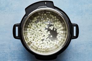 chopped onion being cooked with vegetable oil in an instant pot on sauté mode