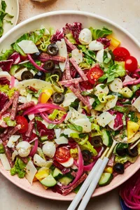 Italian Chopped Salad with homemade Italian salad dressing in a serving bowl with serving spoons on the counter