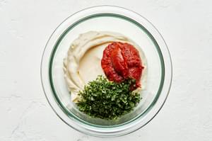 mayonnaise, harissa and chopped mint in a bowl to make harissa mayo for topping homemade lamb burgers