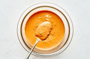 mayonnaise, harissa and chopped mint stirred together in a bowl to make harissa mayo for topping homemade lamb burgers