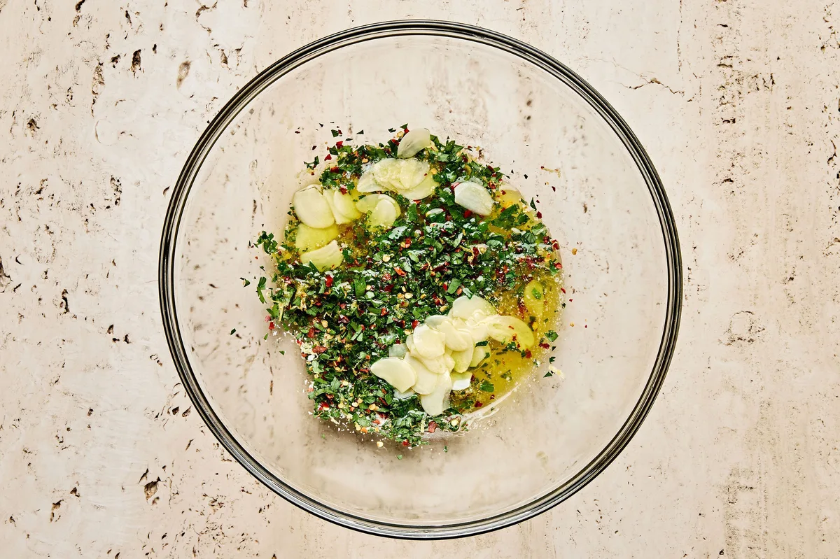 Lemon garlic sauce in a bowl made with olive oil, butter, parsley, lemon juice & zest, garlic, red pepper flakes & salt
