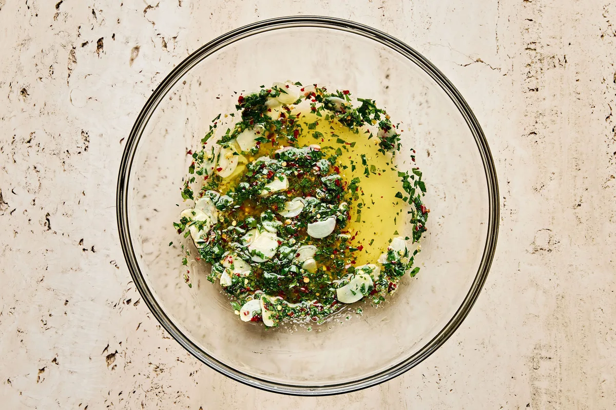 Lemon garlic sauce in a bowl made with olive oil, butter, parsley, lemon juice & zest, garlic, red pepper flakes & salt