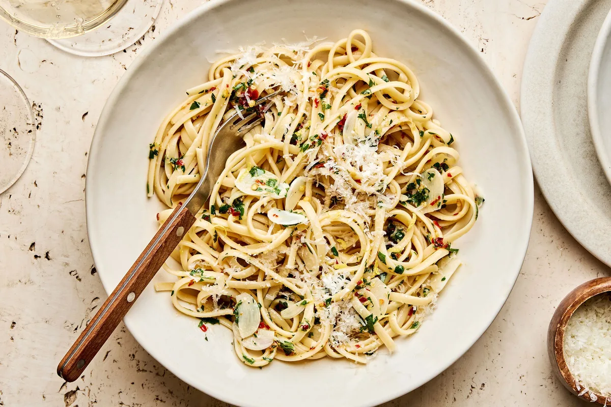 A bowl of linguine pasta tossed in a silky lemon garlic sauce, garnished with freshly grated Parmesan