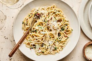 A bowl of linguine pasta tossed in a silky lemon garlic sauce, garnished with freshly grated Parmesan