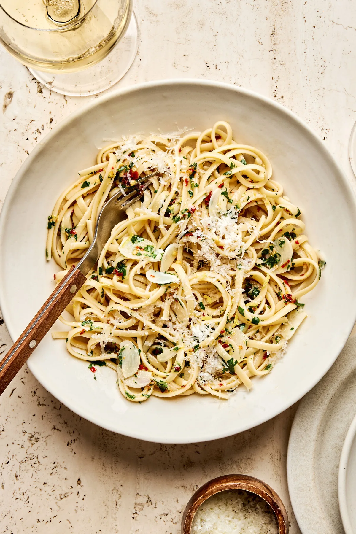 A bowl of linguine pasta tossed in a silky lemon garlic sauce, garnished with freshly grated Parmesan
