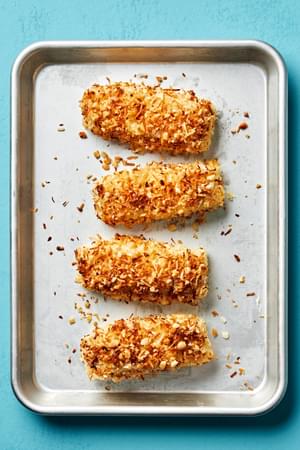 baked fish crusted with macadamia nuts and coconut on a baking sheet for making a macadamia nut crusted fish bowl