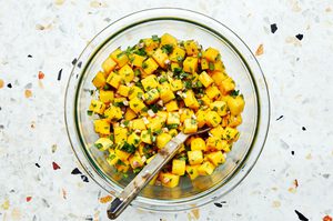 diced mango, red onion, jalapeño, cilantro, and lime juice being tossed in a bowl to make fresh mango salsa
